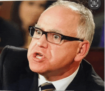 a man in a suit and tie with glasses making a funny face