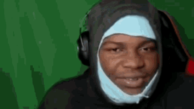 a man wearing headphones and a bandage on his head .