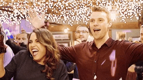 a man and a woman are standing next to each other in a crowd of people .