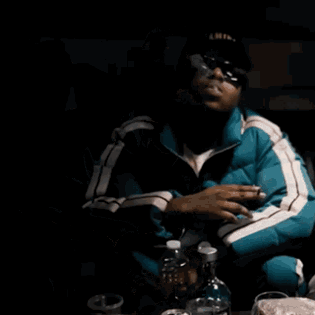a man wearing a jacket that says palm angels smoking a cigarette