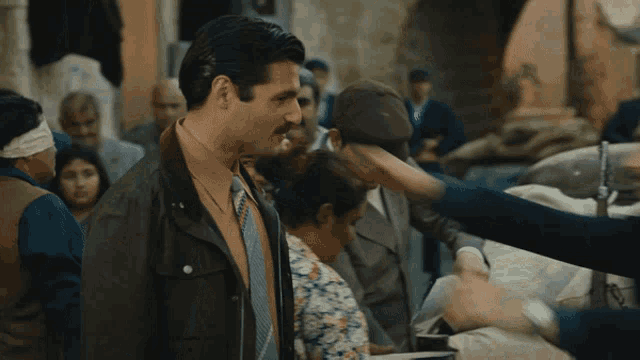 a man with a mustache is hugging another man in a crowd of people