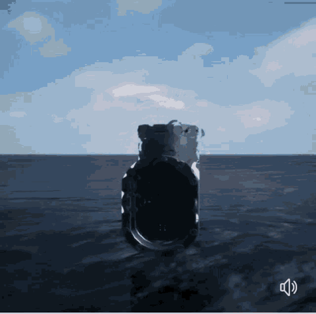 a black object in the middle of the ocean with a sound icon