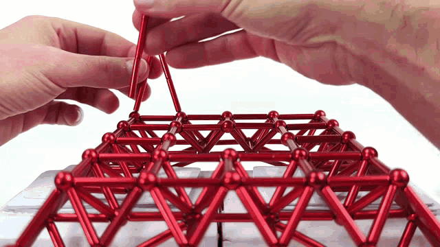 a person is playing with a red magnetic toy
