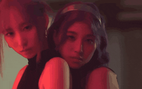 a couple of women standing next to each other with red lights on their faces