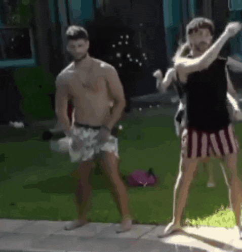 a shirtless man and a woman are dancing in front of a pool .