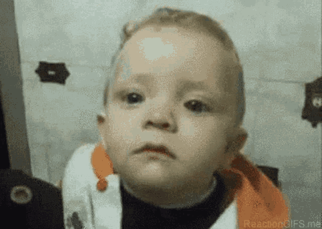 a close up of a baby making a funny face .