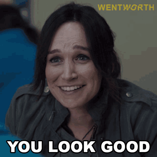 a woman is smiling with the words " you look good " behind her