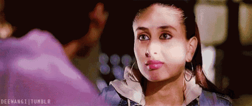 a woman in a denim jacket and hoop earrings is looking at a man .