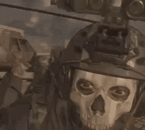 a soldier with a skull mask on his face is wearing a helmet and holding a gun .
