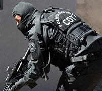 a man in a black uniform is holding a rifle .