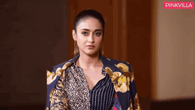 a woman is wearing a leopard print jacket and a striped shirt