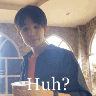 a young man holding a cup with the word huh written on it