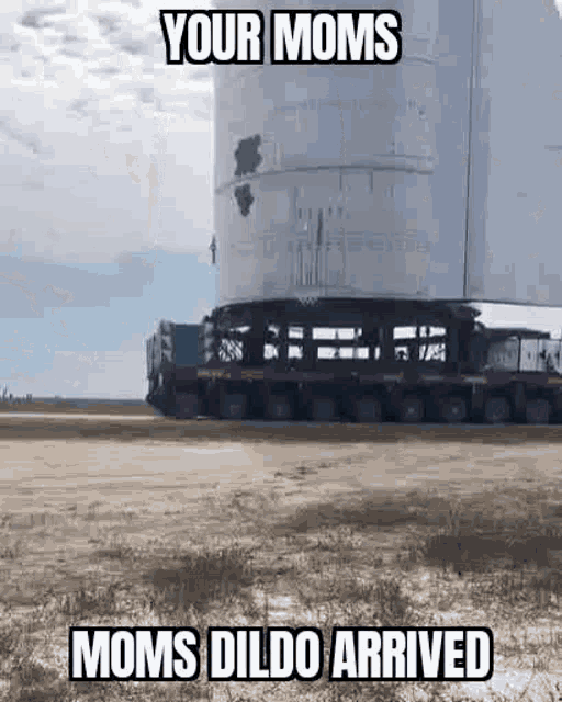 a large rocket is being loaded on a truck in a field .