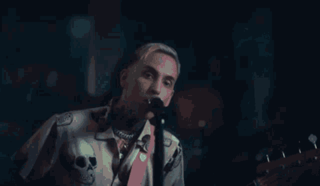 a man singing into a microphone while holding a guitar .