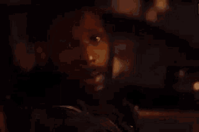 a man with a beard is sitting in a dark room looking at the camera .