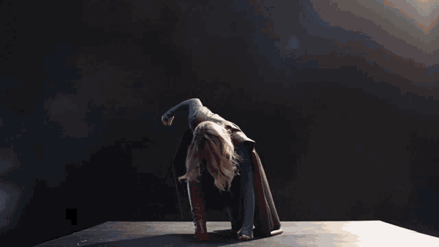 a woman in a supergirl costume kneeling down
