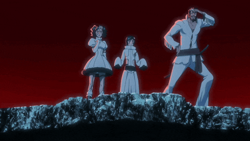 a man and two women standing on top of a rock