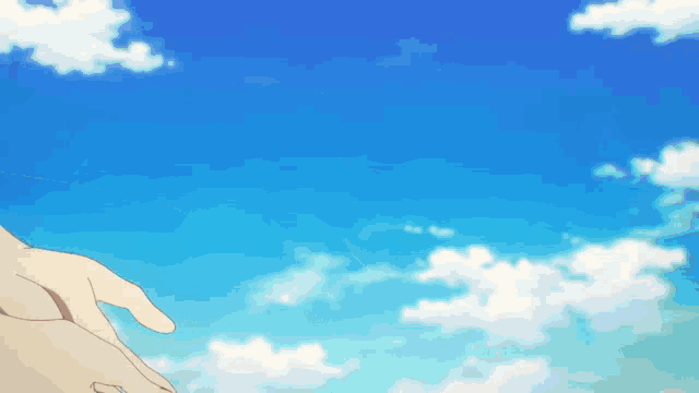 a person 's hand is reaching out towards a blue sky with clouds