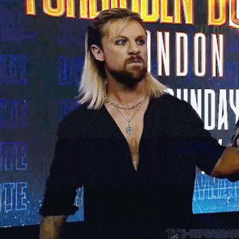 a man with long blonde hair and a beard is standing in front of a sign that says london sunday .