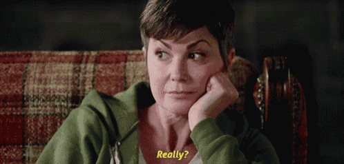 a woman in a green hoodie is sitting in a chair with her hand on her chin and says really .