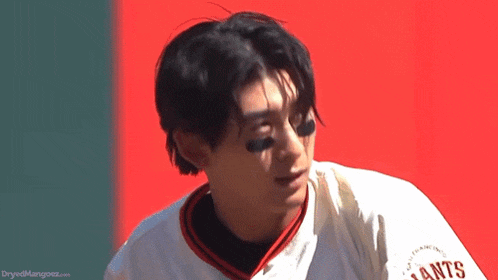 a man wearing a giants jersey is looking at something