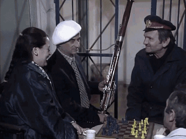 a group of people are playing chess and a man is holding a rifle
