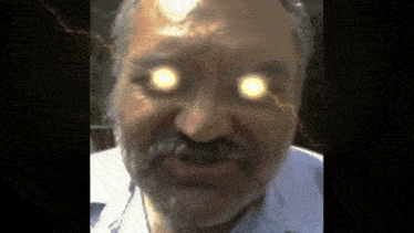 a close up of a man 's face with lightning coming out of his eyes