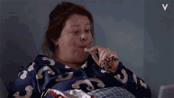 a woman in a rainbow pajama eating chips