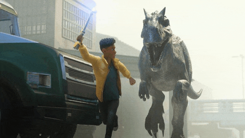 a boy is running away from a dinosaur while holding a sword in his hand .