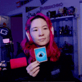 a woman with red hair wearing headphones and holding a card with an apple logo on it