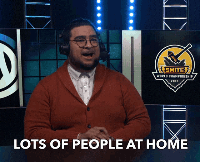 a man wearing headphones and a red sweater says " lots of people at home "