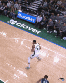a basketball player with the number 34 on his jersey is dribbling the ball