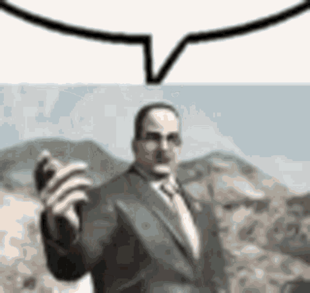 a man in a suit and tie is holding a cell phone in his hand .