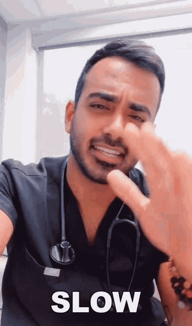 a man with a stethoscope on his neck is making a slow gesture