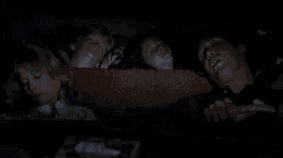 a man is sleeping in the back seat of a car with two children .