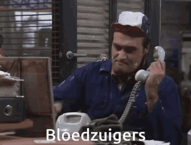 a man talking on a phone with the word bloedzuigers on the bottom right