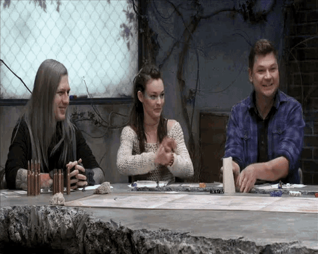 a group of people sitting around a table with bullets on the table