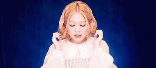 a woman with blonde hair is wearing a white dress and holding her hair in front of her face .