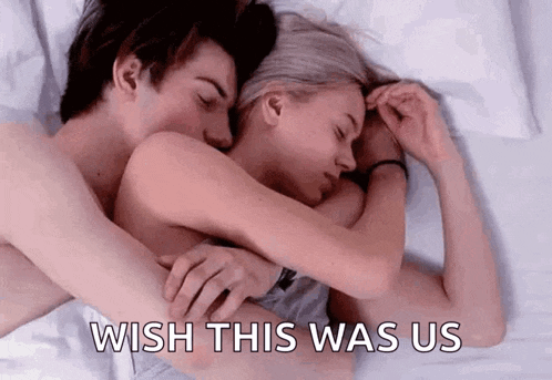 a man and a woman are laying in bed hugging each other and the woman is saying `` wish this was us '' .