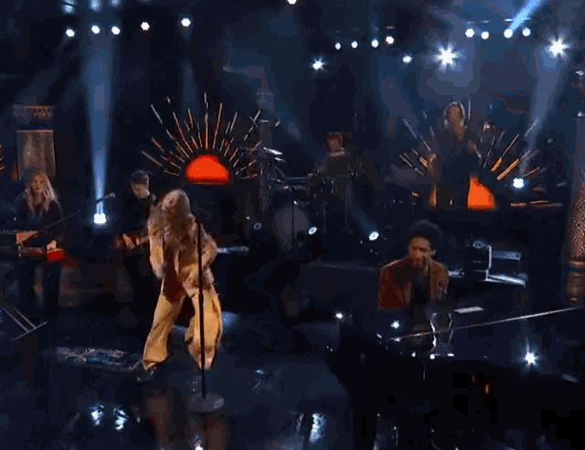 a woman with long hair is dancing on a stage