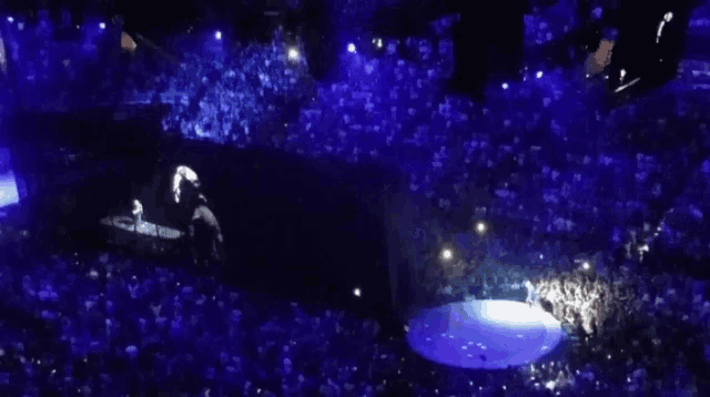 a man is playing a piano in front of a crowd of people .