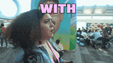 a woman is standing in front of a wall with the word with on it
