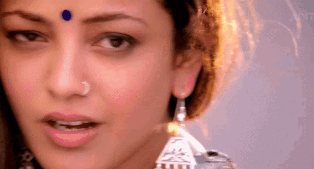 a close up of a woman 's face with a bindi on her forehead