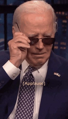 a man in a suit and tie is wearing sunglasses with the caption [ applause ]