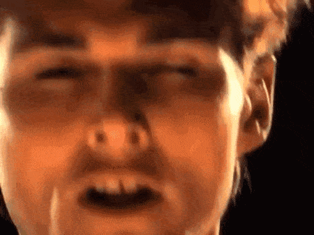 a close up of a man 's face with his eyes closed and mouth open .