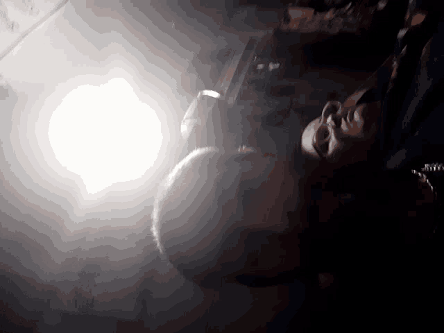 a man laying down with a light shining on his face