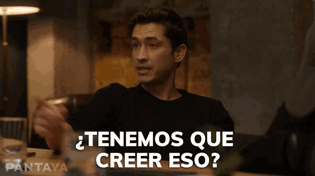 a man is sitting at a table with the words tenemos que creer eso