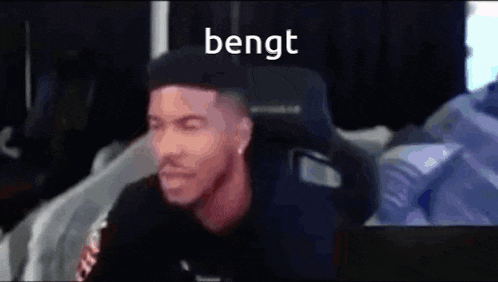 a man is sitting in a chair with the word bengt written on the bottom of his face .