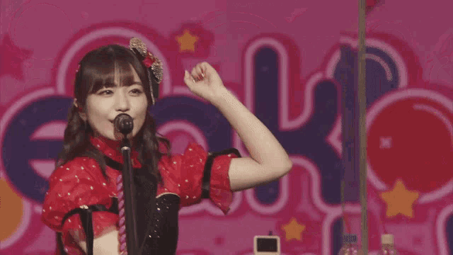 a girl singing into a microphone in front of a sign that says " rock "