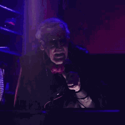 a man wearing headphones is singing into a microphone in a dark room